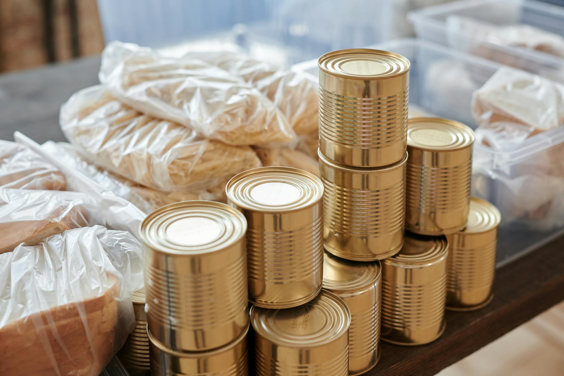 A stack of canned goods and packaged foods on a table, perfect for donation drives.